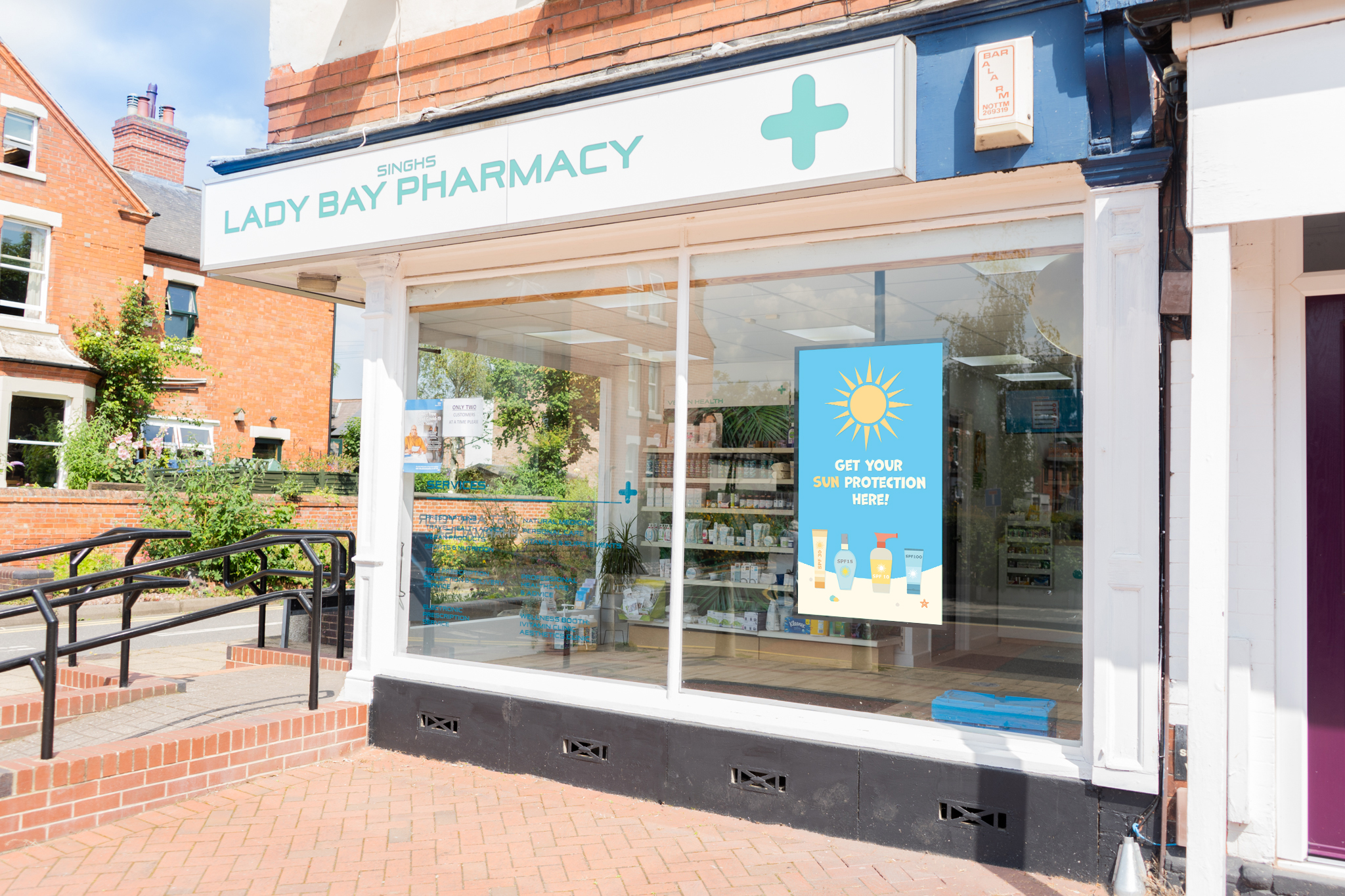 Exterior of pharmacy showing shop windows on sunny street corner of suburban area